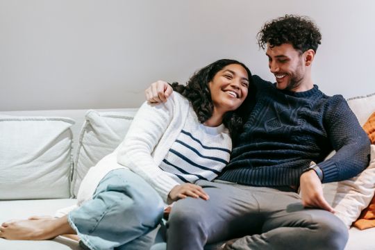Couple cuddling on a couch 7 Signs Your Relationship Needs More Passion and How to Rekindle It
